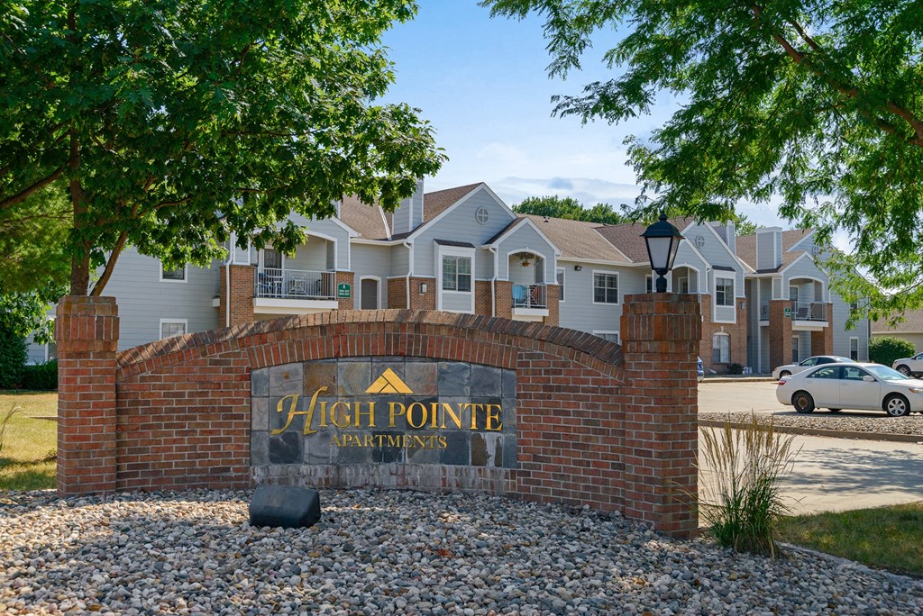 a high point apartments sign in front of a brick wall