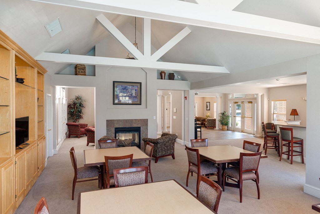 a living room with tables and chairs and a fireplace