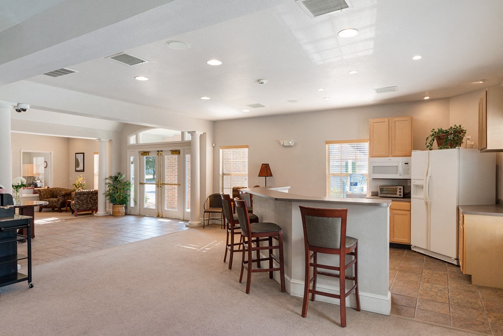 an open kitchen and living room with a large island and chairs