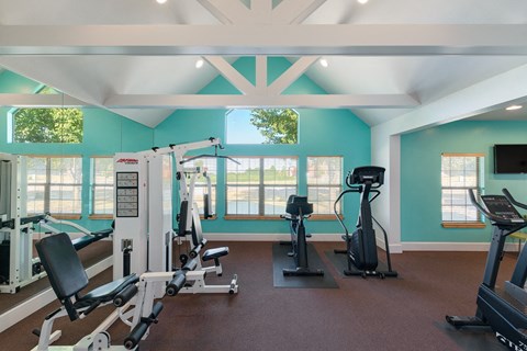 a gym with weights and other exercise equipment and windows