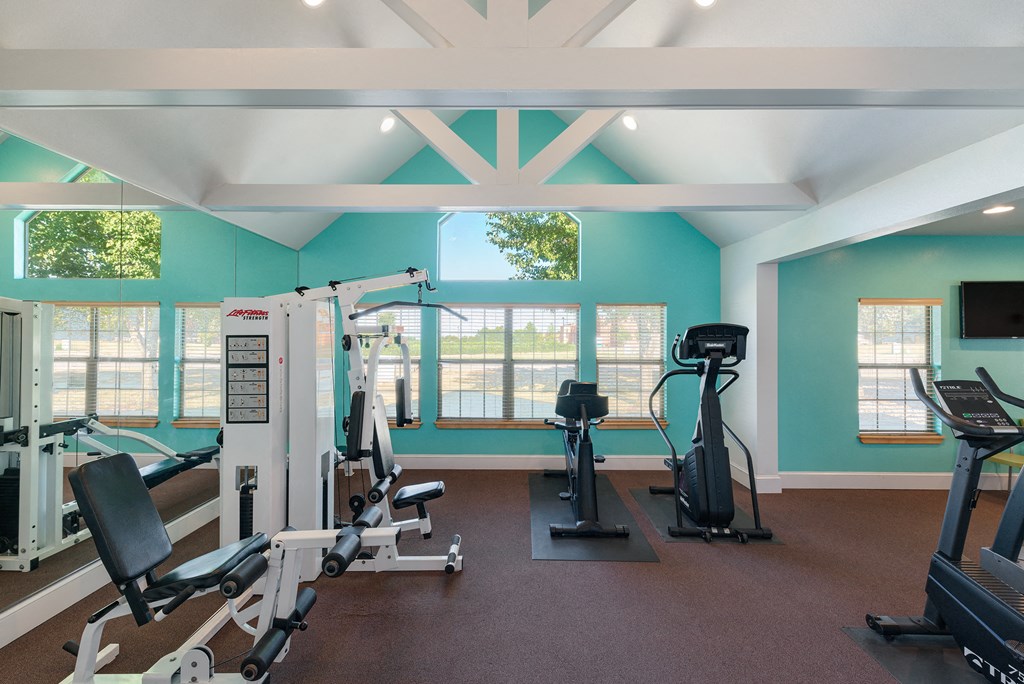 a gym with weights and other exercise equipment and windows