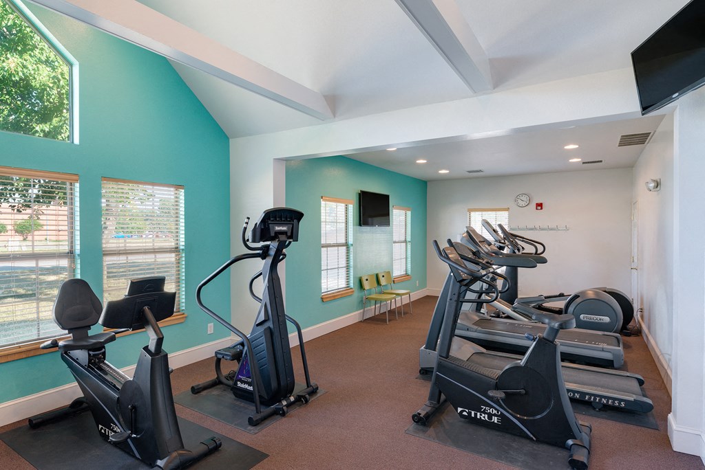 an exercise room with treadmills and other fitness equipment
