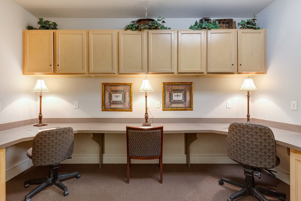 an office with two desks and two chairs with lamps