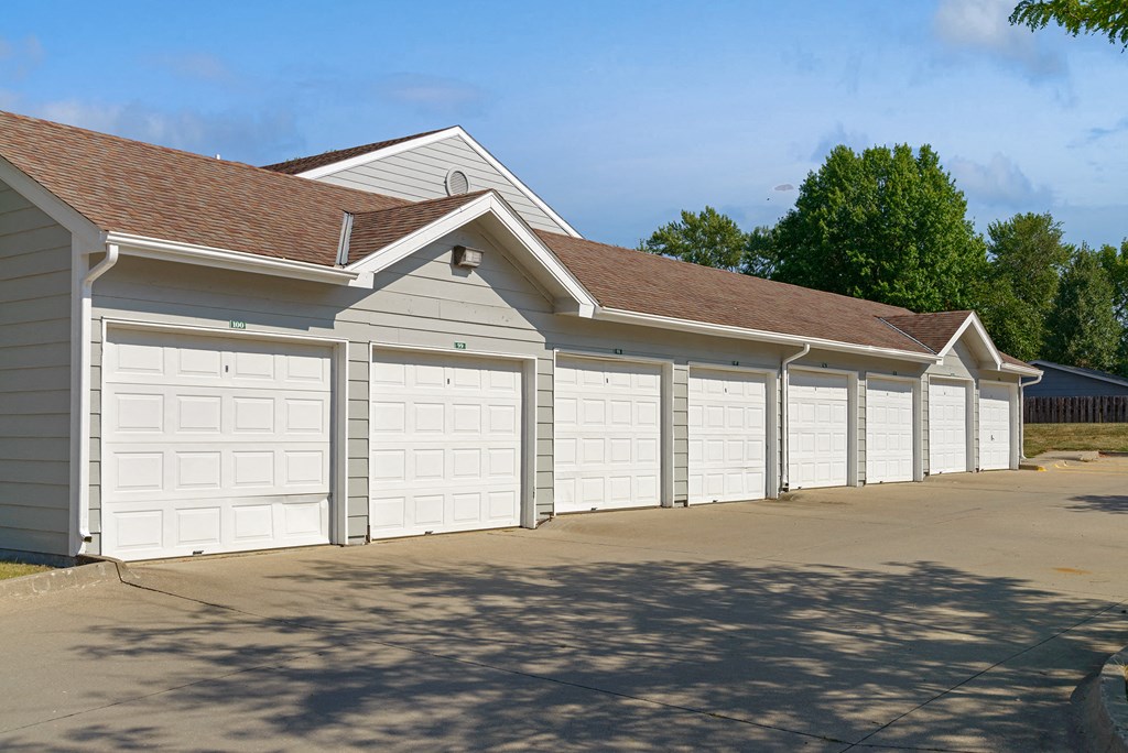 a row of garages with white doors and a driveway