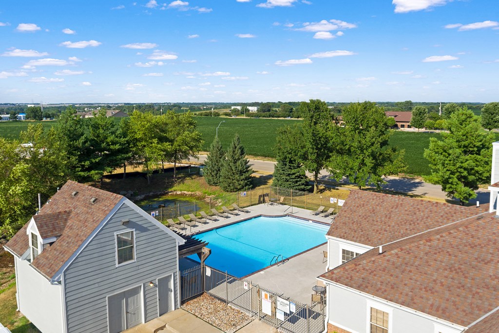an aerial view of a swimming pool and a house with a roof