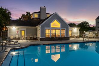 a swimming pool in front of a house at dusk