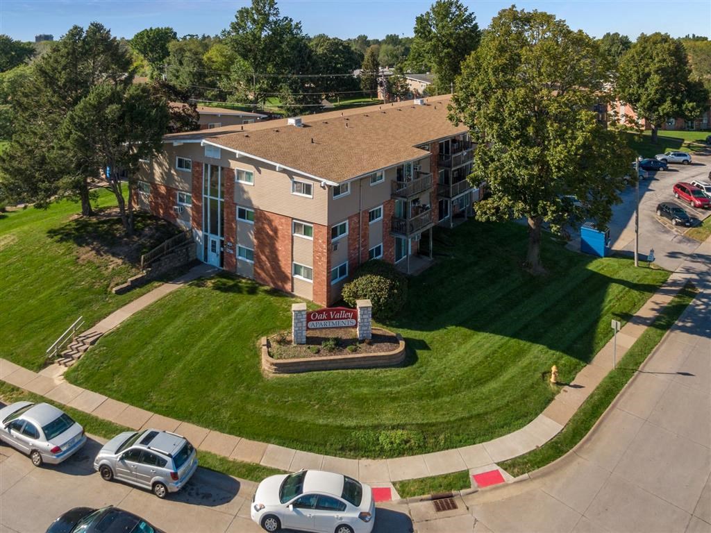 an aerial view of an apartment building with cars parked in front of it