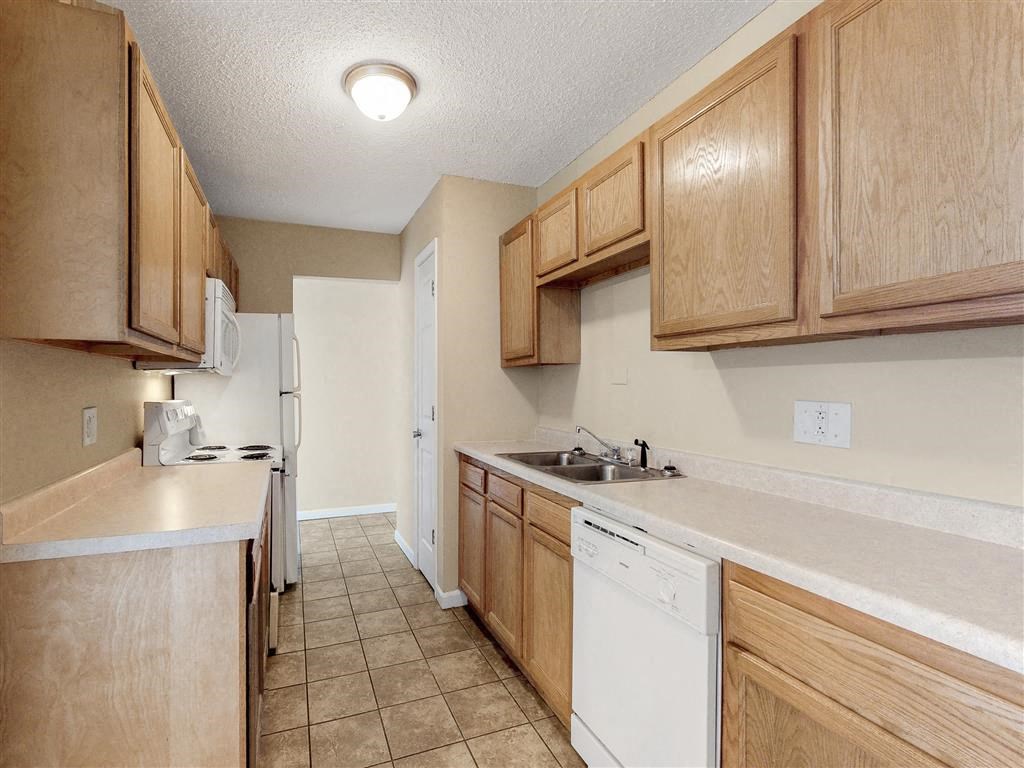 a kitchen with white appliances and wooden cabinets