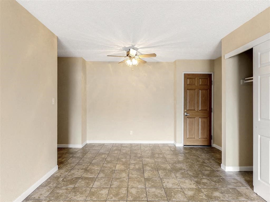 an empty living room with a ceiling fan