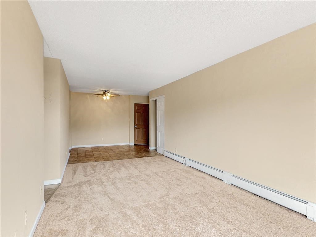 an empty living room with a ceiling fan