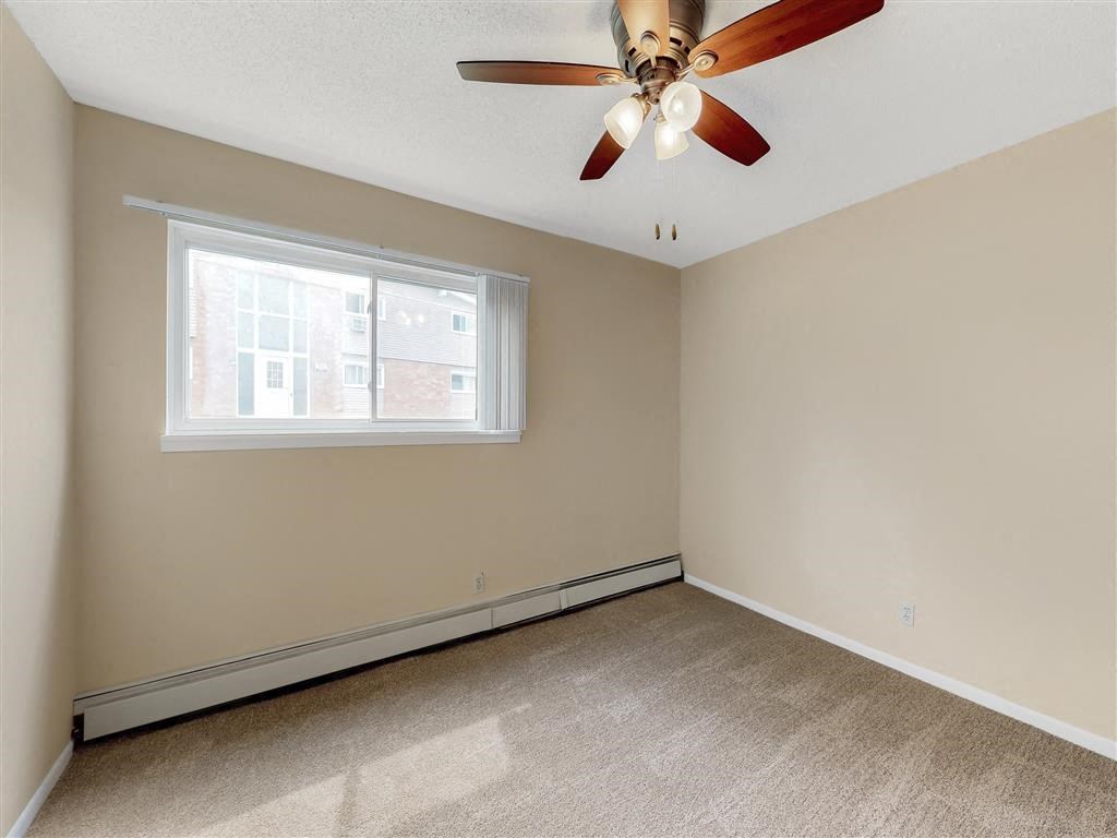 a bedroom with a ceiling fan and a window