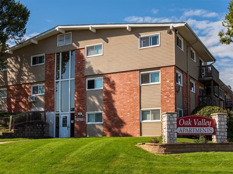 an apartment building with a yard and a sign apartments