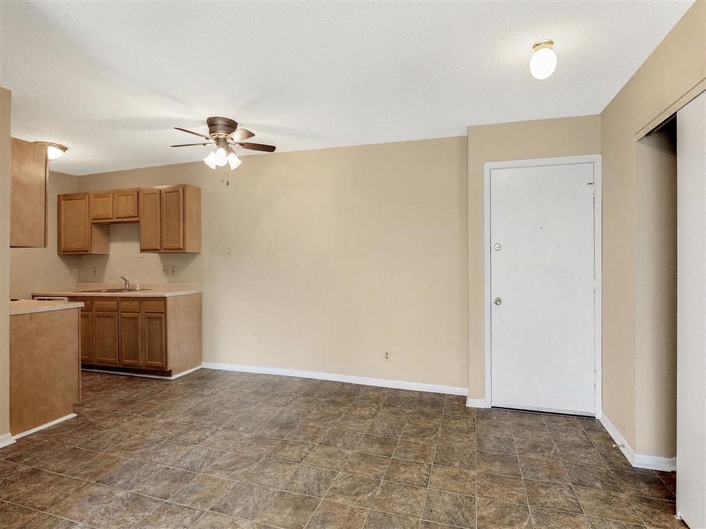 an empty kitchen with a ceiling fan