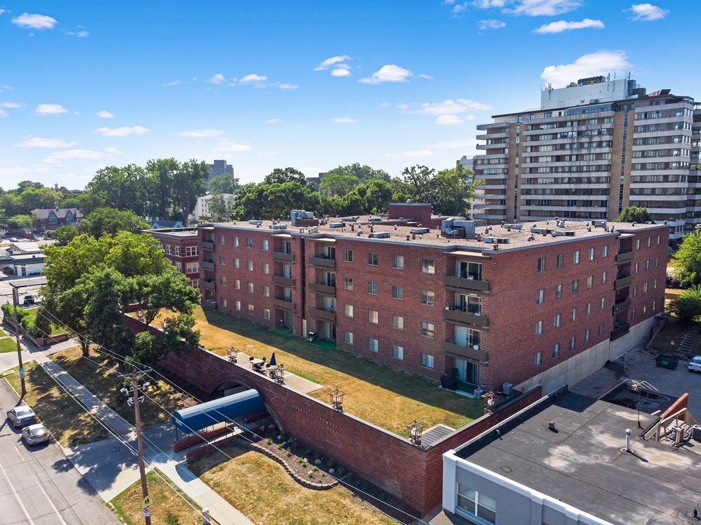 an aerial view of a red brick building with a green lawn