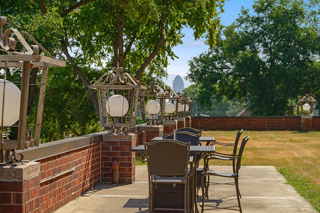 a patio with tables and chairs on a brick wall