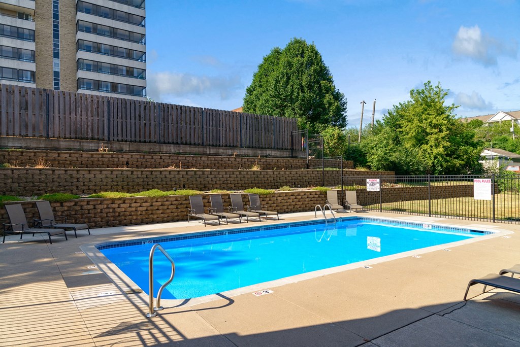 a swimming pool at a hotel with chairs around it