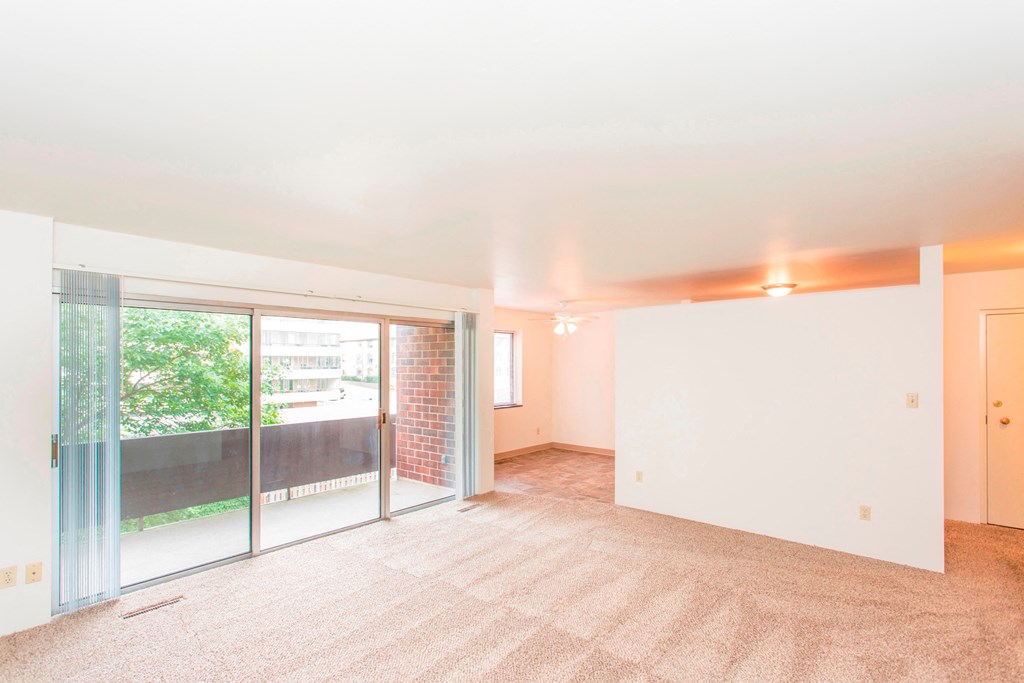 an empty living room with sliding glass doors to a balcony