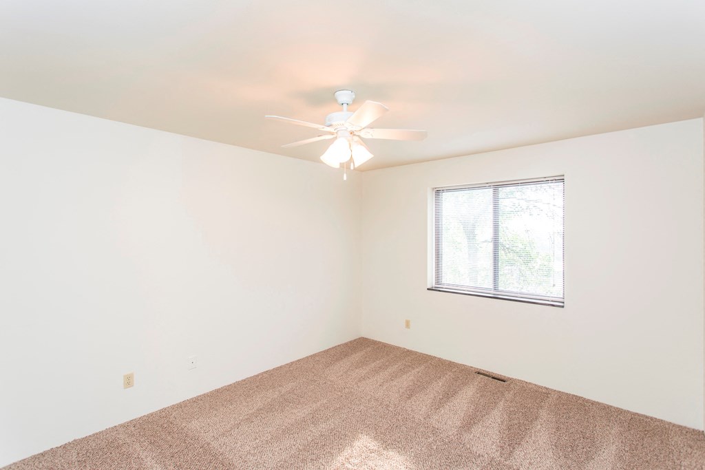 a bedroom with a ceiling fan and a window