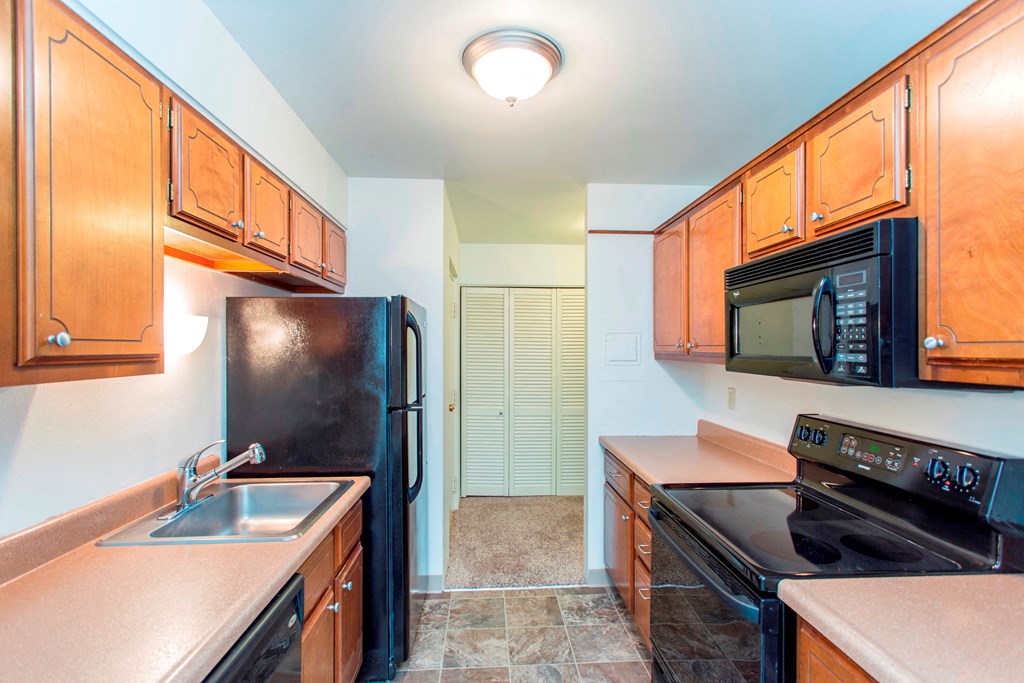 a kitchen with black appliances and wooden cabinets
