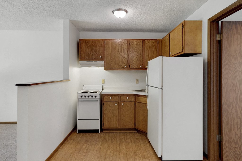a kitchen with white appliances and wooden cabinets