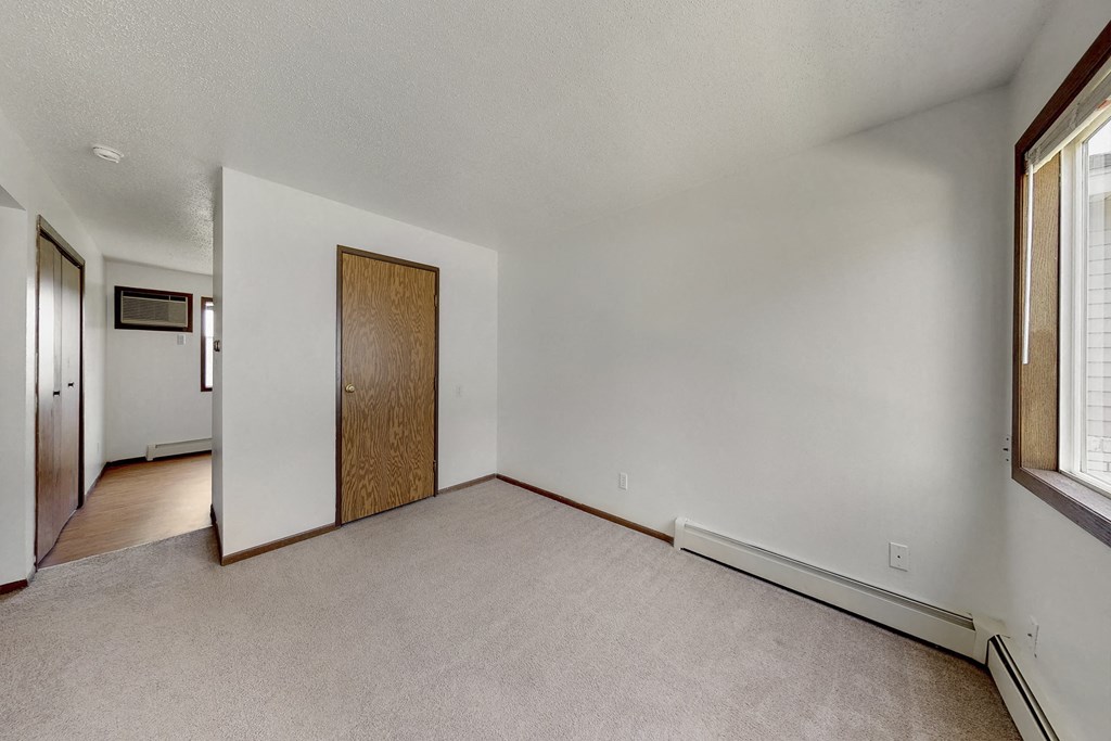 the living room of an empty house with a door to the hallway