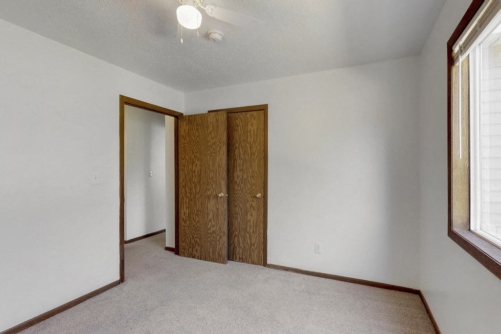 an empty room with white walls and a door to a closet