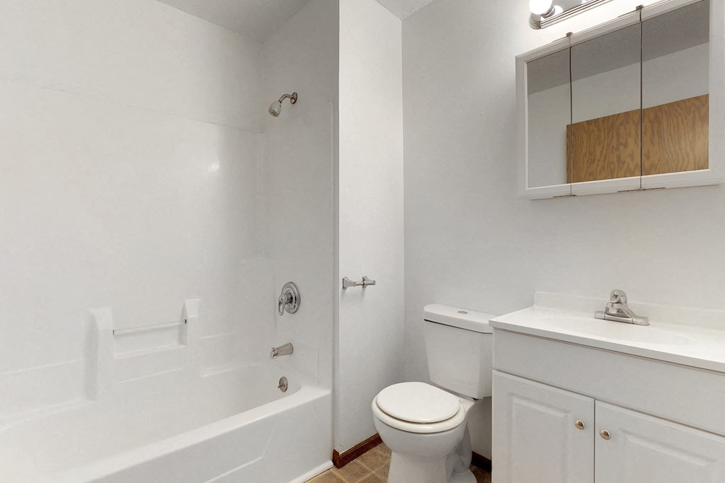 a bathroom with a toilet and a tub and a sink