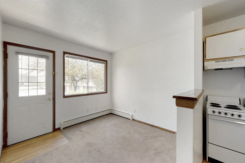 an empty kitchen with a stove top oven and a window