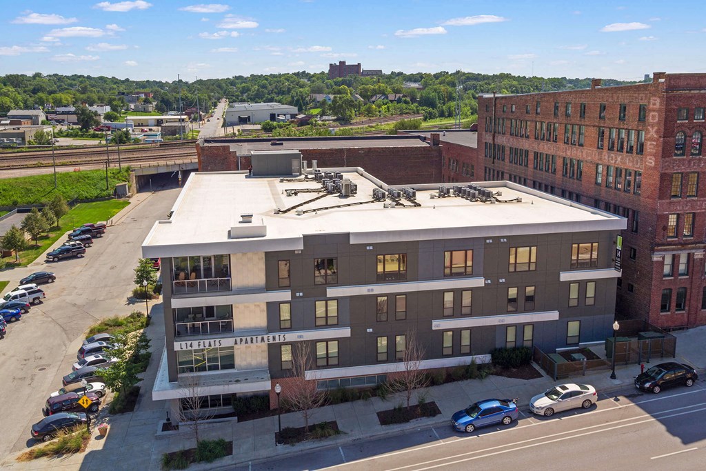 an aerial view of a building with cars parked in front of it