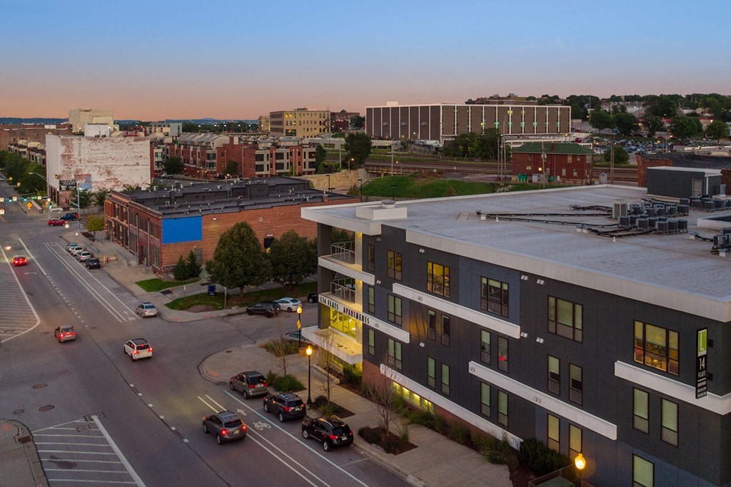 an aerial view of a city street with buildings and cars at dusk