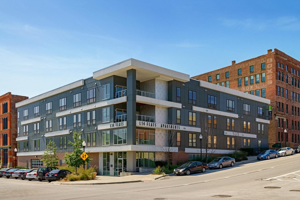 a modern apartment building with cars parked in front of it