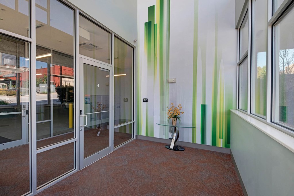 a lobby with glass doors and a vase with flowers