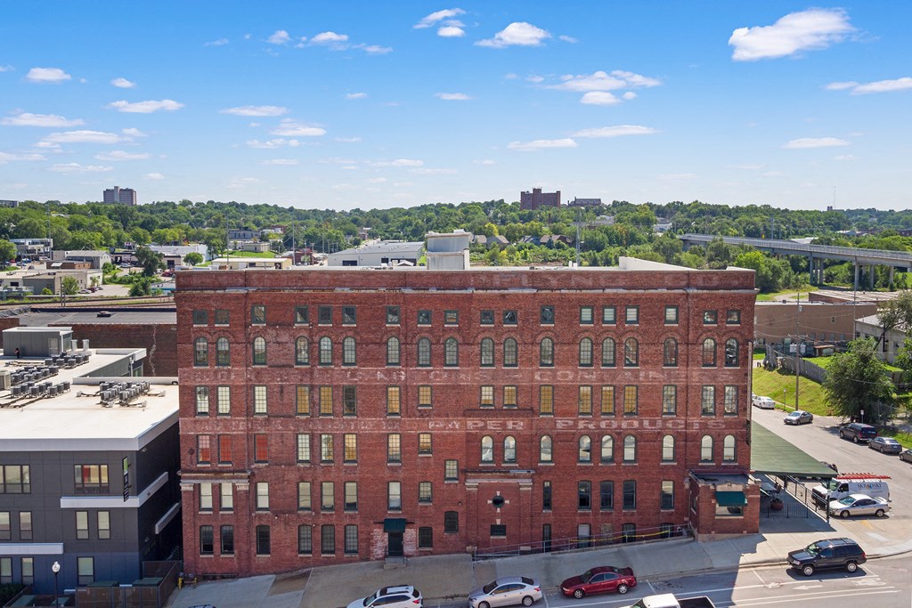 an aerial view of a brick building with a city in the background