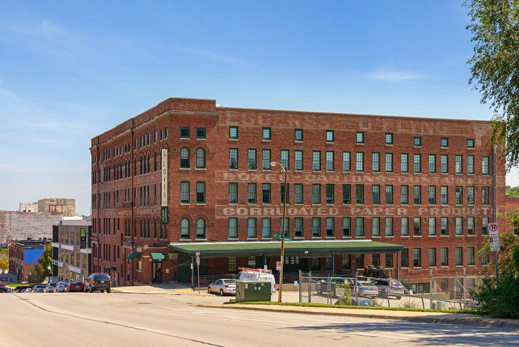 a red brick building with a green awning on a street