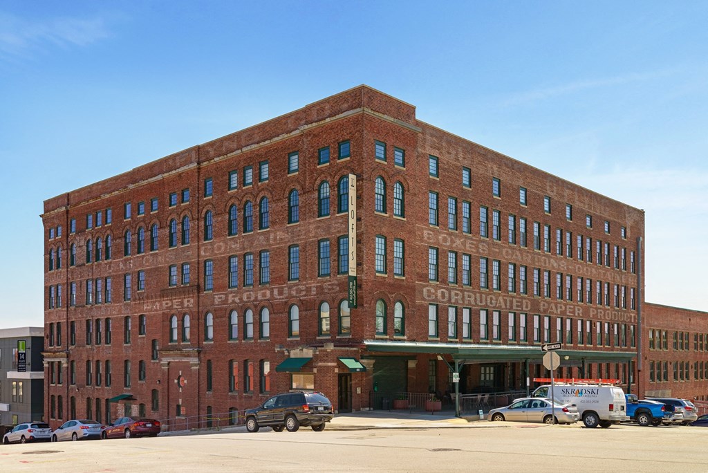 a large brick building with cars parked in front of it