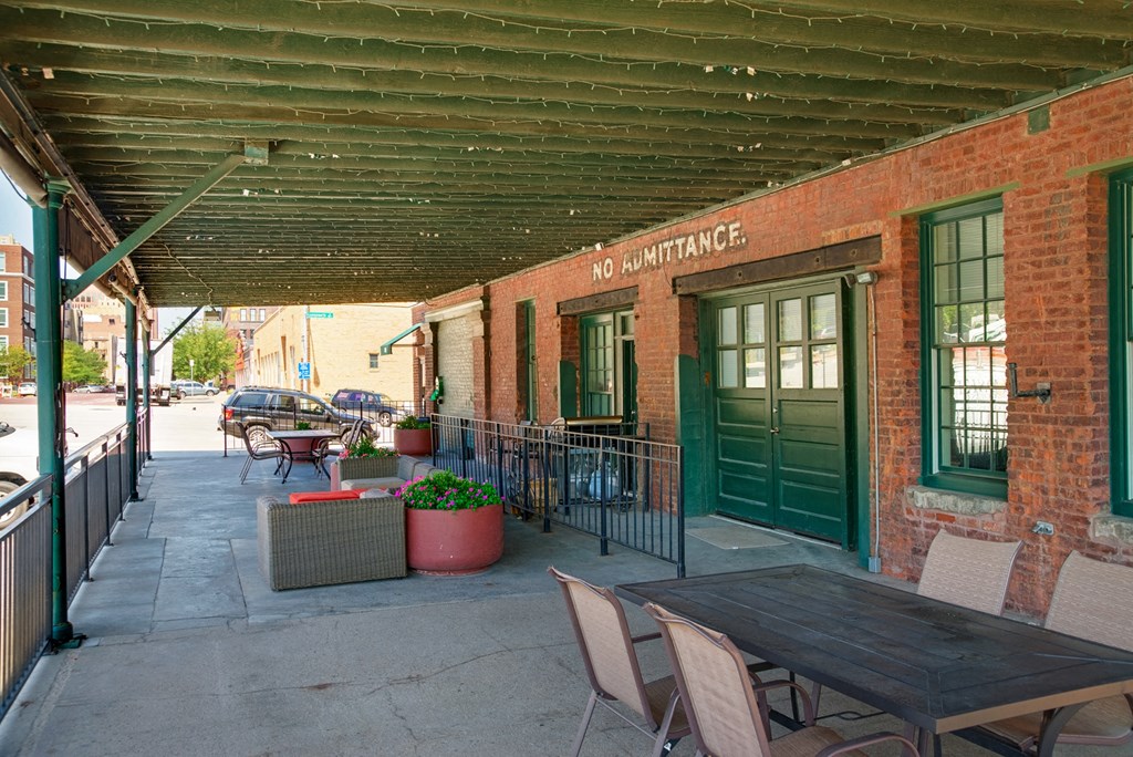 a patio with tables and chairs outside of a brick building