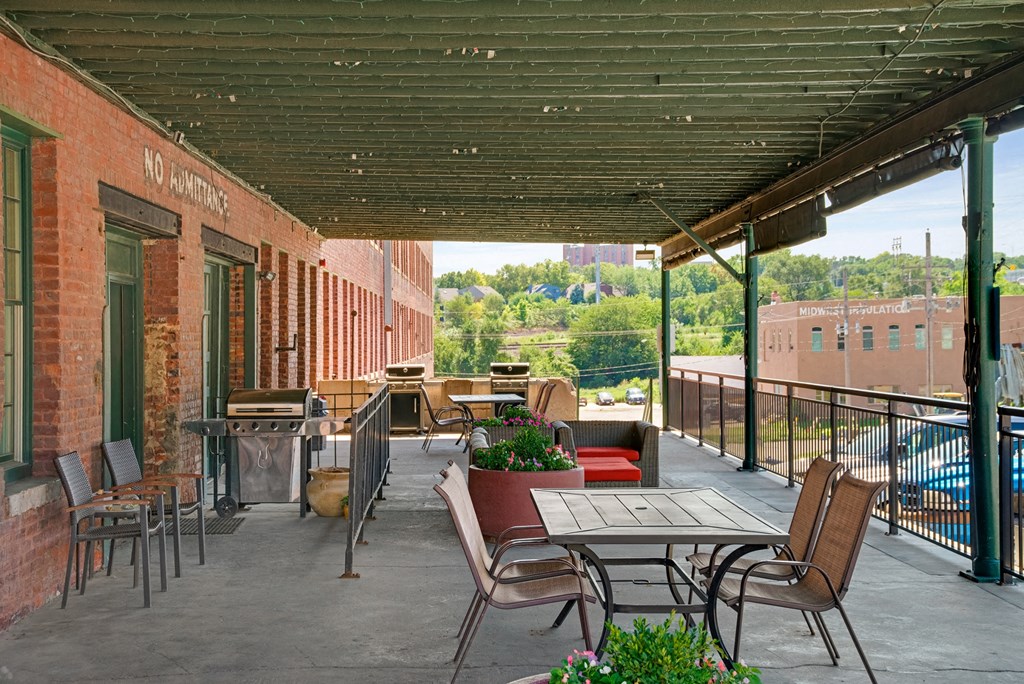 a covered patio with tables and chairs on a building