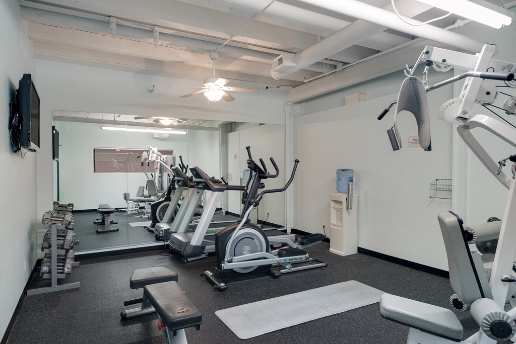a gym with cardio machines and other equipment in a building