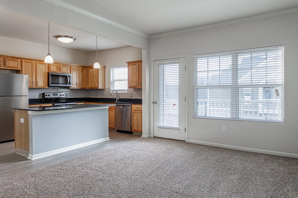 an empty kitchen with a door to the living room