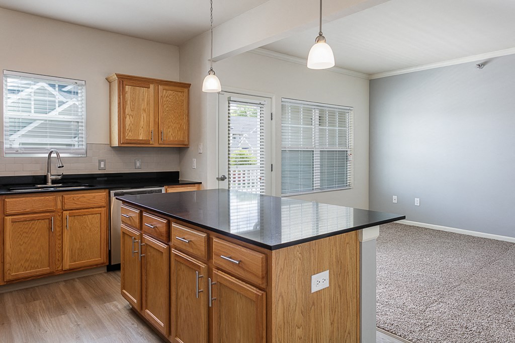 a kitchen with an island and wooden cabinets and a window