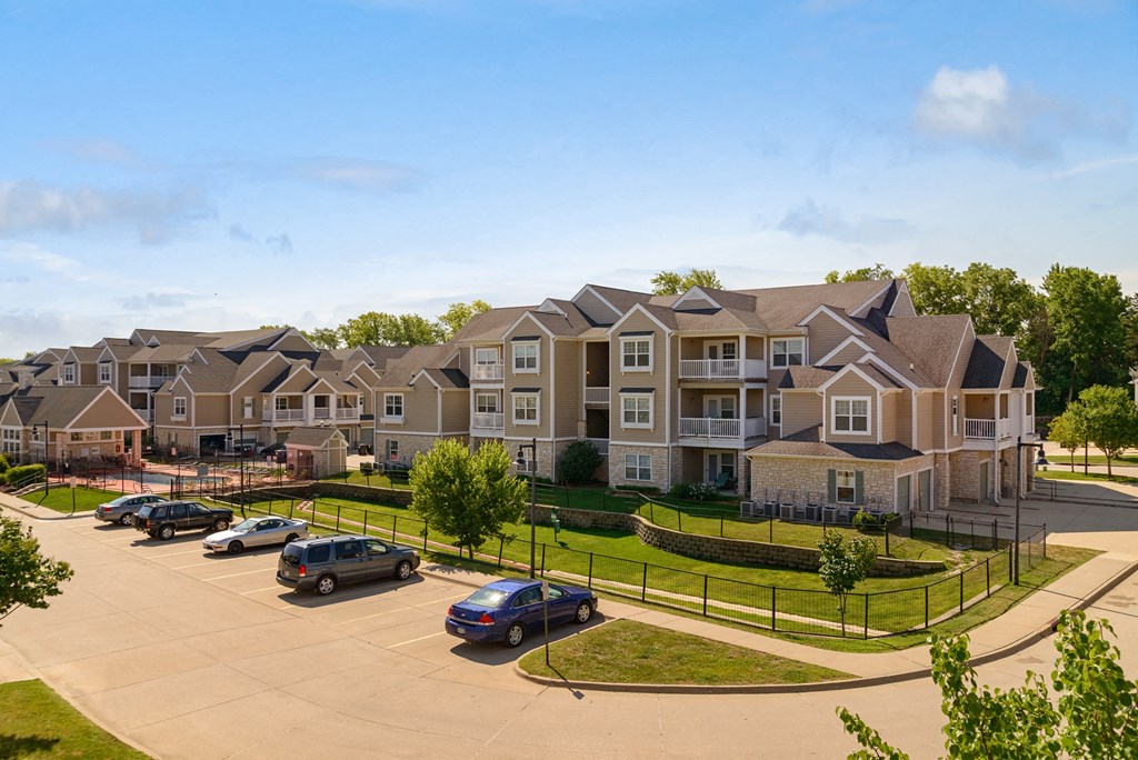an aerial view of an apartment complex with cars parked in a parking lot