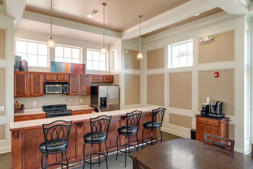 a kitchen with a bar and a table with chairs