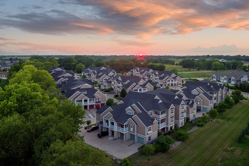 an aerial view of a neighborhood with rows of houses at sunset