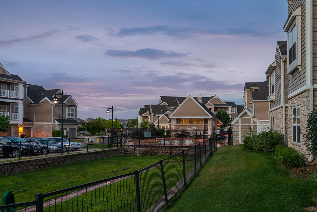 an evening view of a row of homes in front of a green lawn and a