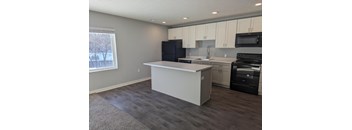 a kitchen with an island and a stove and a window