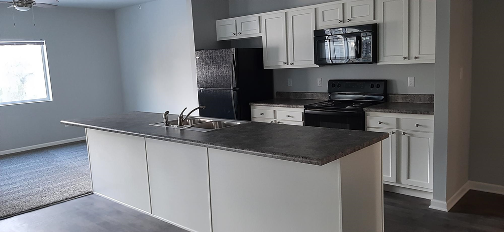 a kitchen with white cabinets and a counter top