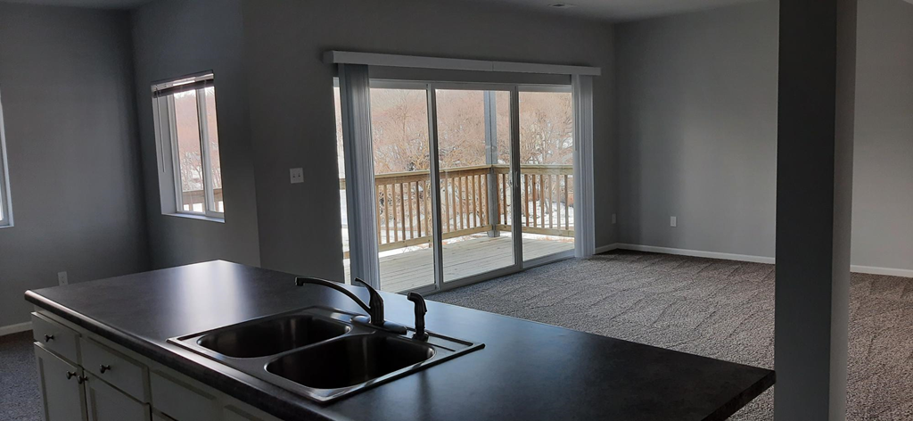 a kitchen with a sink and a sliding glass door to a balcony
