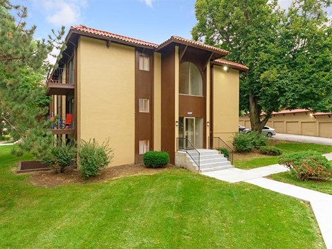 a yellow house with a yard and stairs