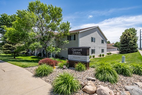 A sign for Oakmont Estates is in front of a building.