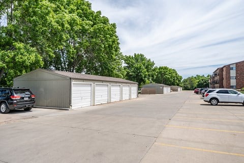 A parking lot with a building and cars.